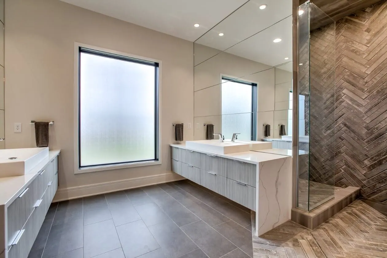 Primary bath with a double vanity and herringbone tile