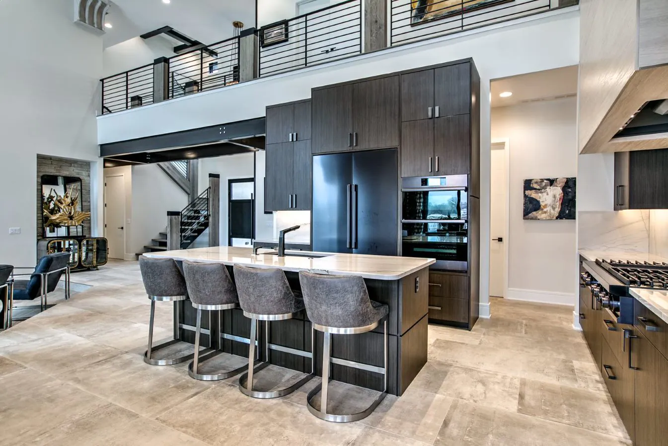 Great-room kitchen with dark rift cabinetry, a waterfall island and a two-story loft by Fox Custom Cabinets
