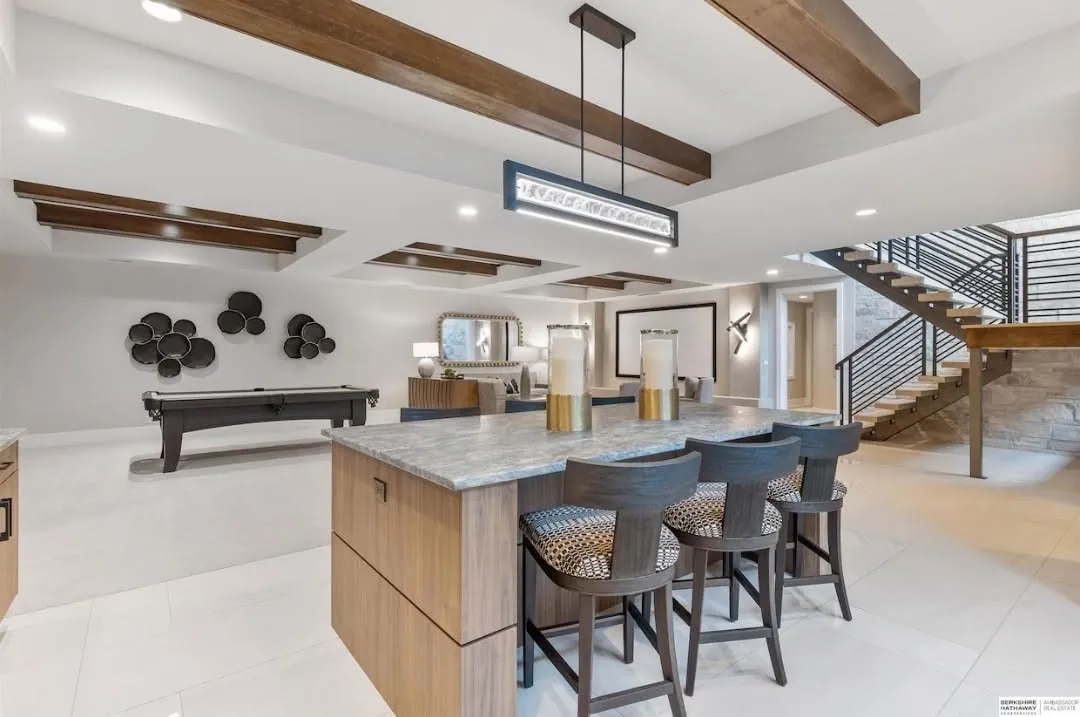 Open great-room kitchen with a marble island and wood beams