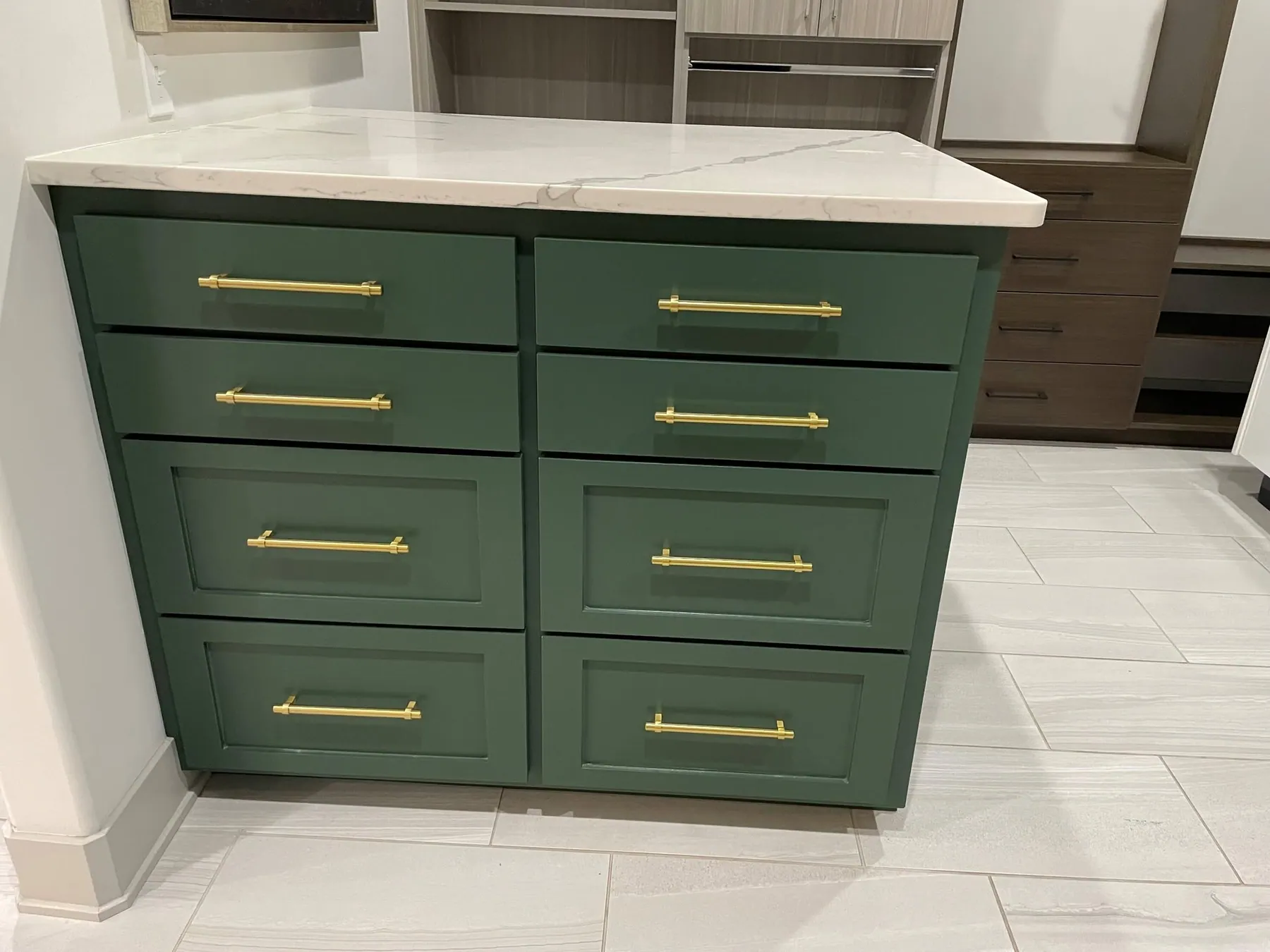 Kitchen with a sage-green shaker island and brass pulls