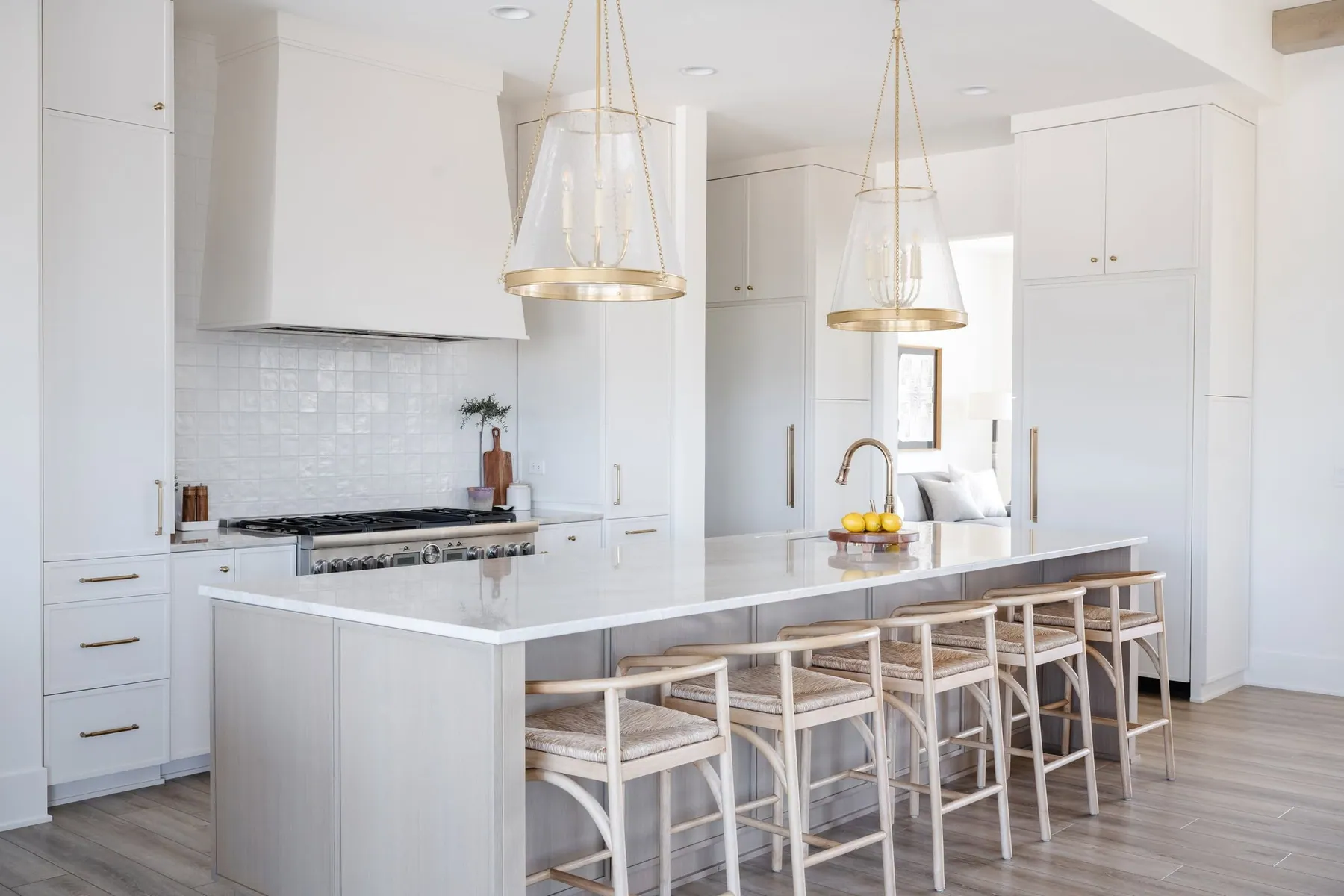 White kitchen with a marble island and statement pendants